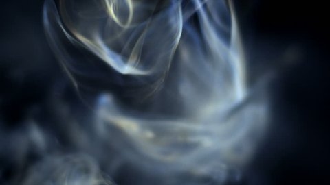 Smoke slowly floating through space against black background. 240 fps slow-motion.