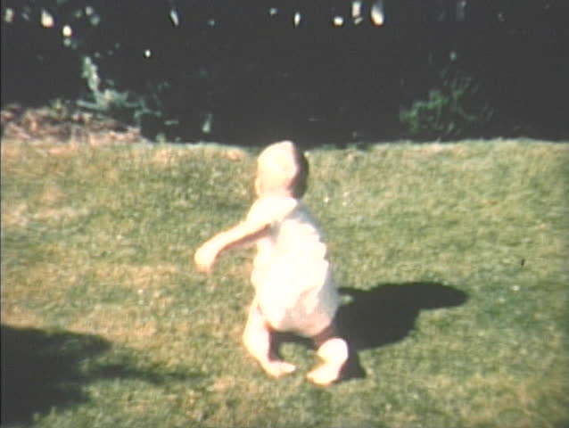 Baby boy crawling on grass in the 1960s home video, Seattle, Washington.
