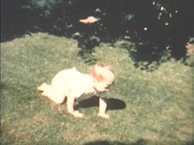 1960s vintage, archival home film footage of baby crawling around in backyard at home in Seattle, Washington, U.S.A.