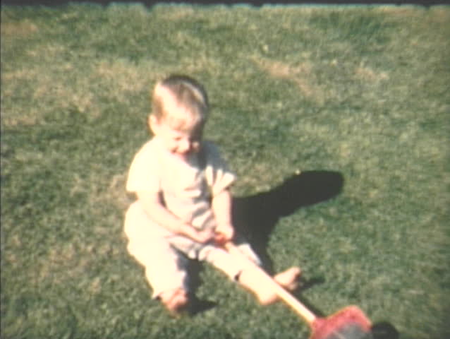 1960s home video footage of baby walking with toy, Seattle Washington.
