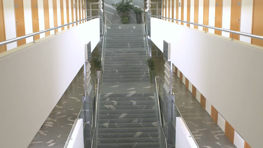 Edited Wide Shot Of A Businessman Ascending The Stairs In Prominent Office