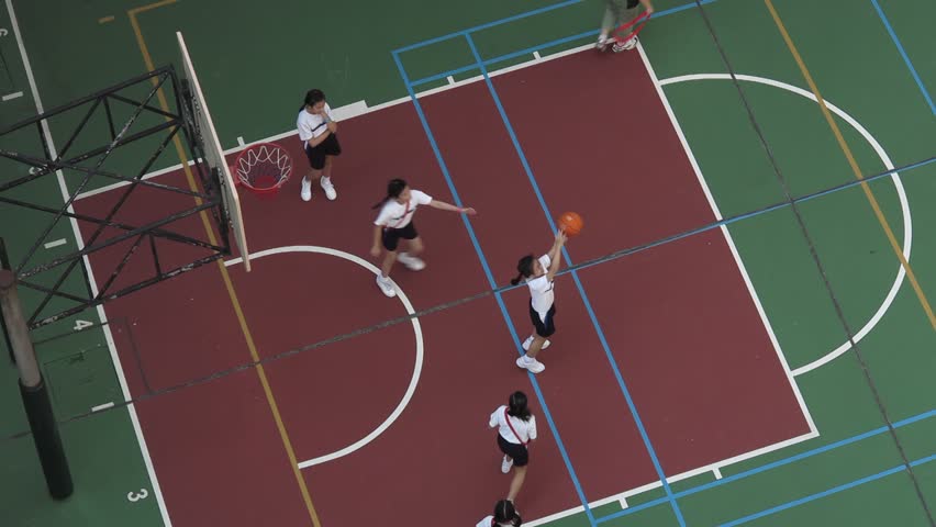 HONG KONG - OCT 25: School kids playing basketball at a basketball court on OCT 25, 2013 in Quarry Bay, Hong Kong, China. Quarry Bay is a residential area where has a lot of schools around. | Shutterstock HD Video #4938752