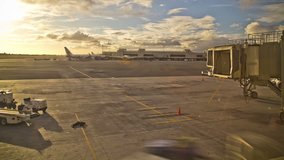 Time lapse clip of airplane arriving at the gate during sunset.