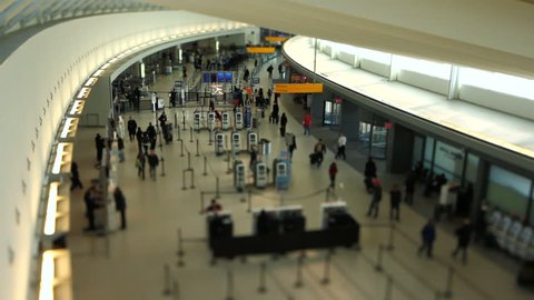 Airport travelers at check in area using a tilt shift lens.