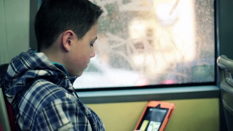 Young boy with tablet computer riding bus
 Stock Video