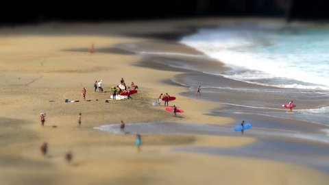 A tilt shift time lapse with surfers leaving a nudist beach. No recognizable people, nudity, trademarks or logos! 11132 
