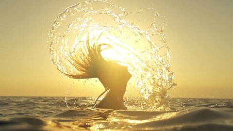 SLOW MOTION: Woman splashes water with her hair