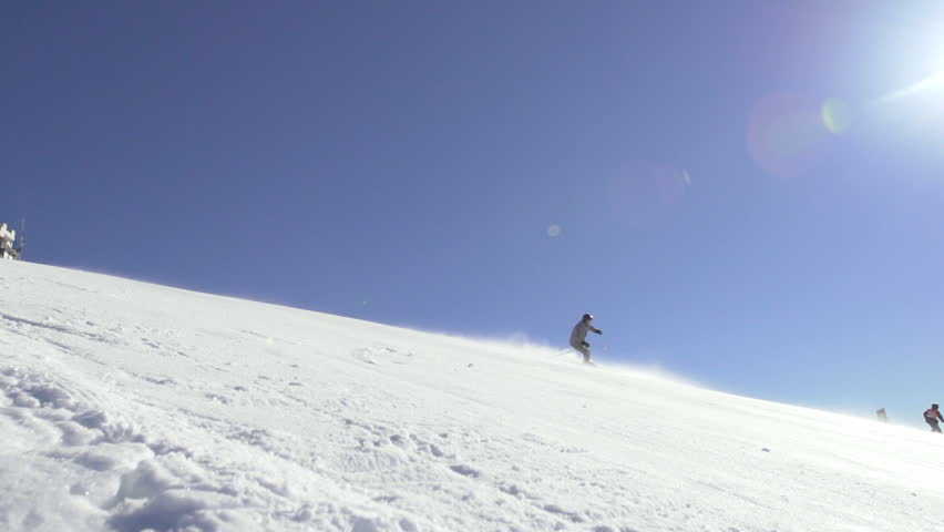 Slow Motion Wide Shot Of A Professional Skier Skiing Downhill On A Steep Terrain