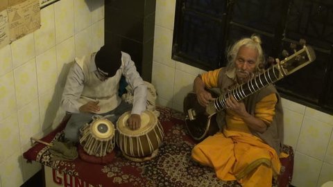 Varanasi, India – December 24: two indian musicians playing with instruments in German bakery restaurant, Varanasi, India on December 24, 2012. Masters playing with tabla drums and sitar