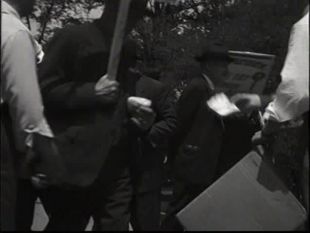 1930s - Unions form in the 1930s at a factory. Workers march and hold signs.