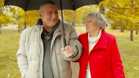 Elderly dates enjoying the walk in the park despite the rain