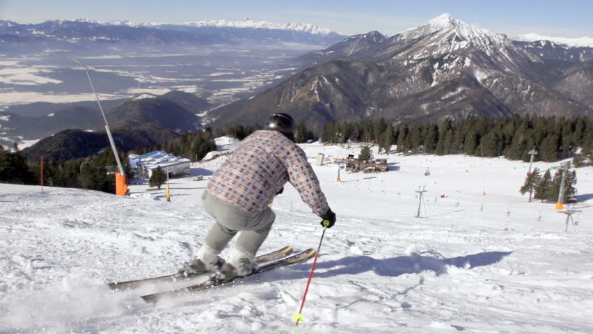 Slow Motion Rear View Of Back-Country Skier Skiing Down The Snowy Slope With