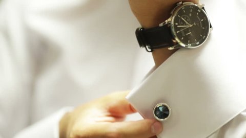 Man wears shiny cufflinks and watching the clock