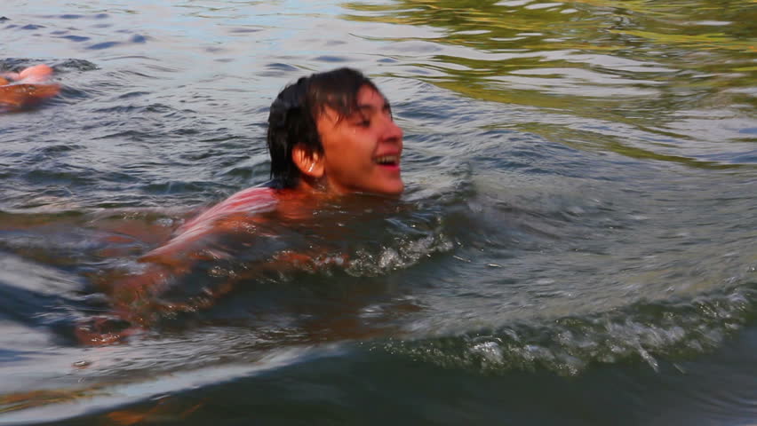 teenager boy swimming in river