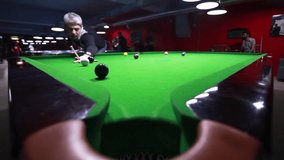 A young man playing snooker, hits the ball and scores some points/I can´t miss this one