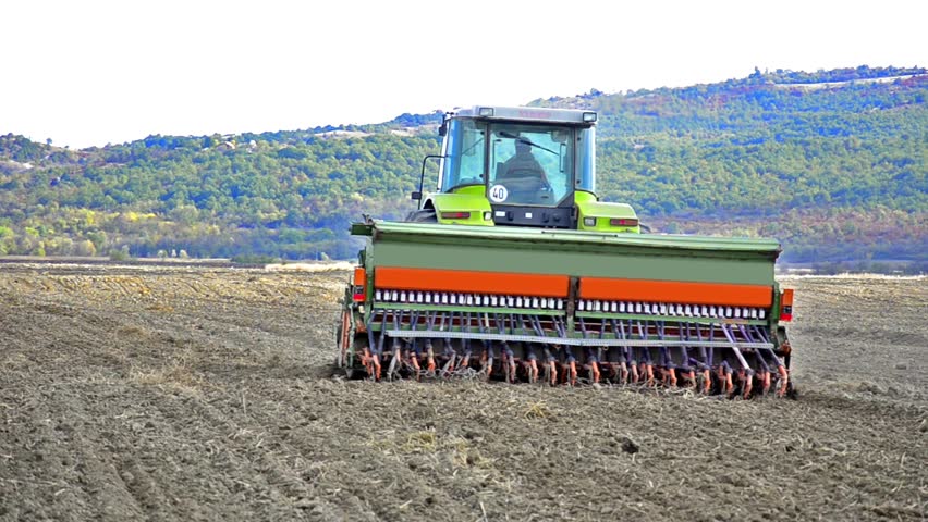 Agricultural tractor sowing and cultivating field
