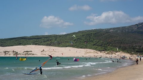 a large beach filled with kite surfers in tarifa, one of europe's most popular areas for the sport
