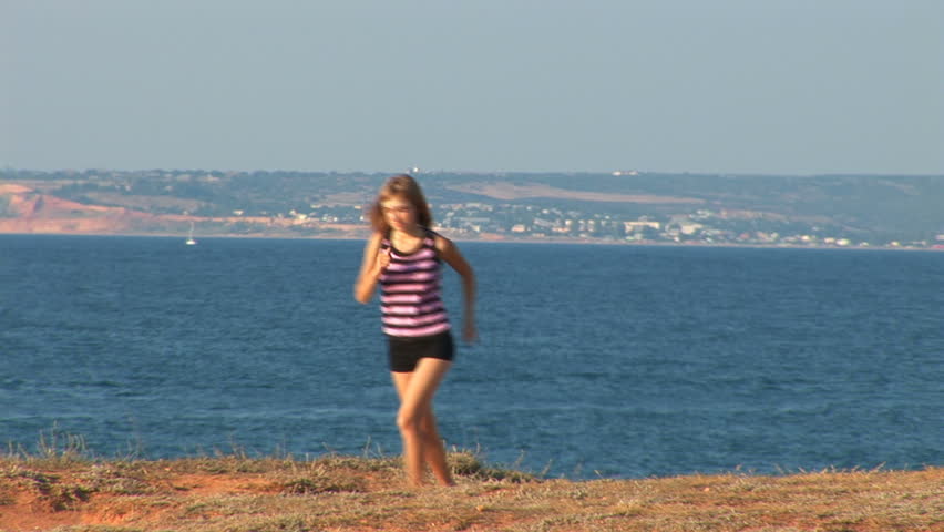 The young woman jogs along the seaside. 