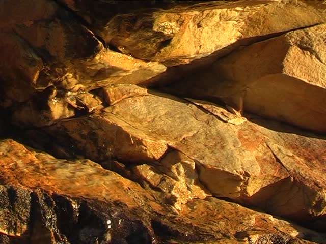 Water drops running from a fountain in the mountains