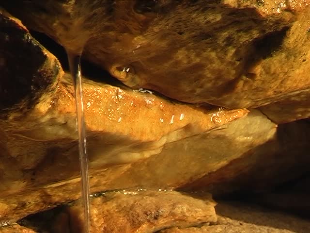Water drops running from a fountain in the mountains