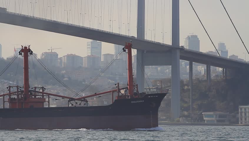 Marine air pollution. Istanbul city skyline in smog with a cargo ship
