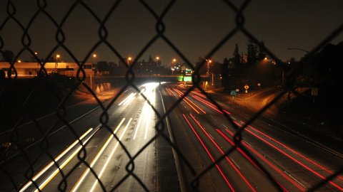 Time Lapse of Traffic through Chain Link Fence - 4K Vídeo Stock