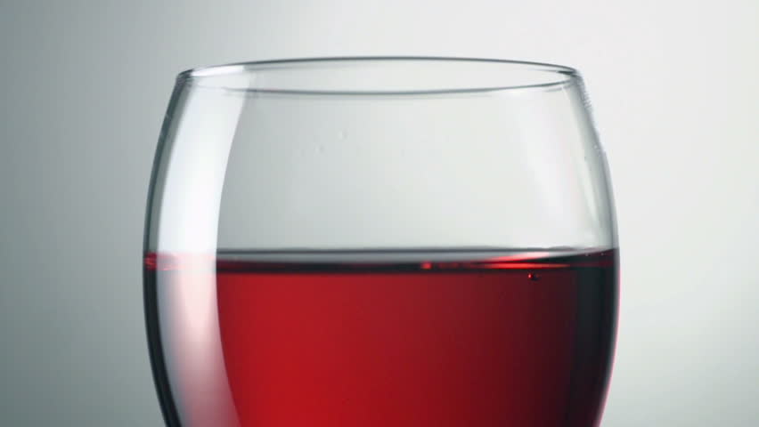 red wine being dropped into glass shot in super slow motion