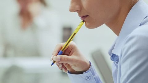 Business woman writing during corporate presentation in meeting room, with colleague out of focus in background, 3of20