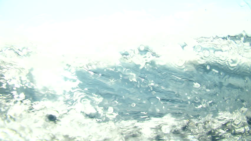 Sea water surface with blue sky and big curly wave splitted by waterline to