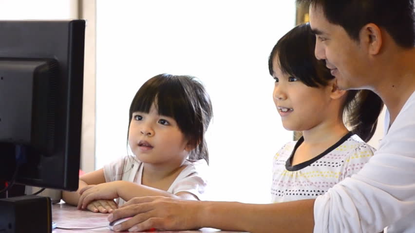 Asian Father And Cute Daughters Playing Computer