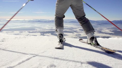 Slow Motion Rear View Of Skier Skiing Down The Snowy Slope With Spectacular Mountain Peaks Panoramic View