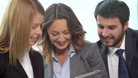 Close-up of business workers having fun using a tablet computer