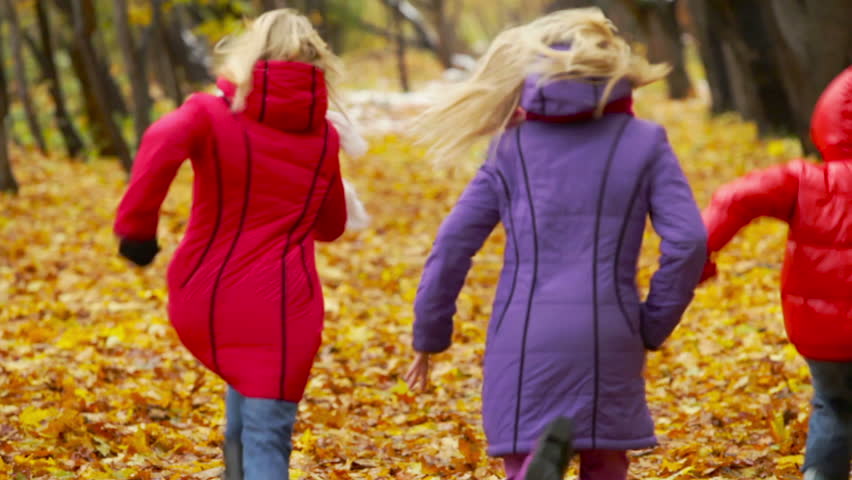 Energetic friends running fast away into the woods