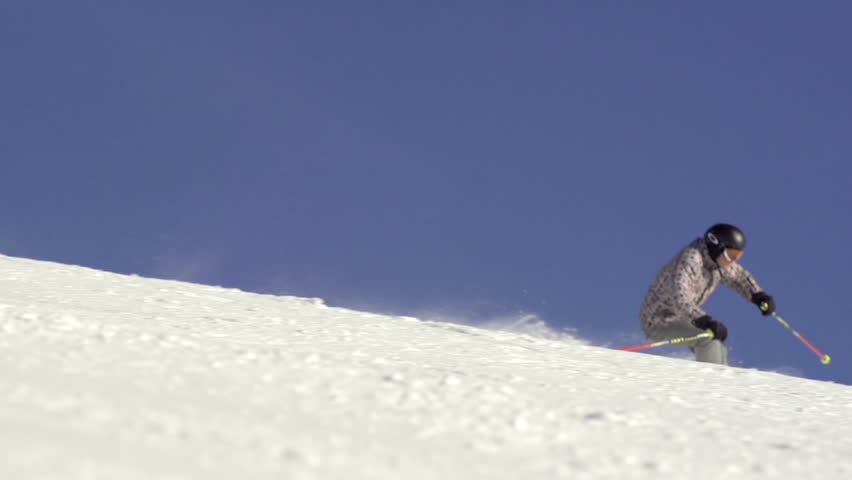 Slow Motion Of Skier Carving Fast Down The Snowy Hill With Snow Drifting Behind