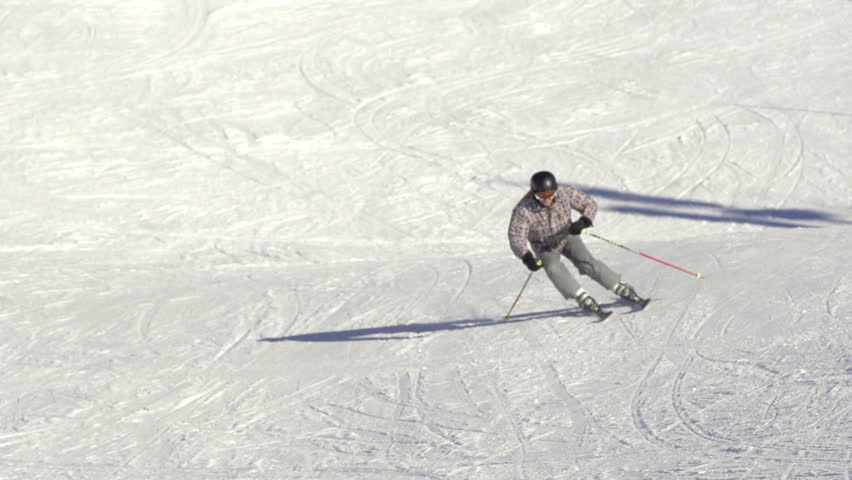 Slow Motion Total Shot Of Skier Carving Down The Wide Snow Covered Ski Track 