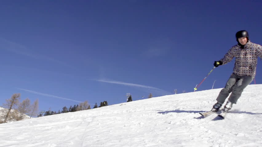 Slow Motion Of Skier Carving Down The Slope And Spraying Snow Onto The Camera