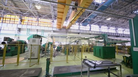 Overhead crane moves in large workshop with equipment for aluminum rolling at metallurgical factory
