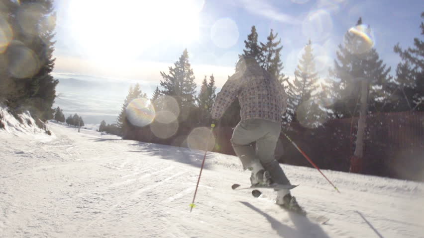 Slow Motion Of Professional Skier Carving Down The Slope. Shot With Nice Flares