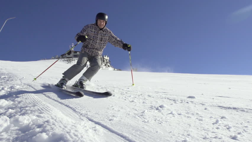 Slow Motion Front View Of Skier Carving Down The Ski Track And Spraying Snow