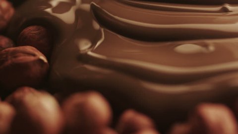 Real Liquid Chocolate Covers Hazelnuts. No CG used. Close-Up. Shot on RED Digital Cinema Camera in 4K (ultra-high definition (UHD)), so you can easily crop, rotate and zoom, without losing quality.