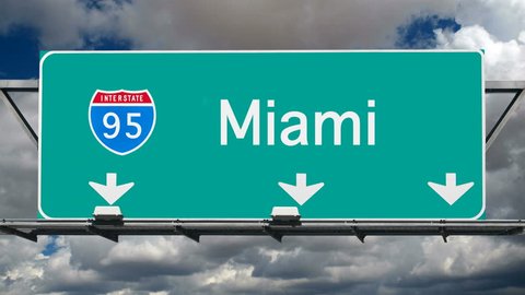 Miami Interstate 95 overhead freeway sign with time lapse clouds.