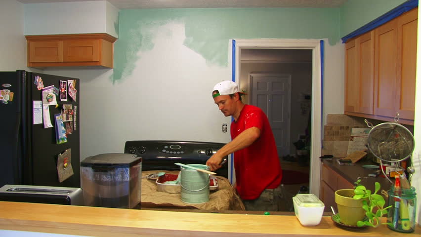 Man and woman couple paint kitchen, time lapse sequence.
