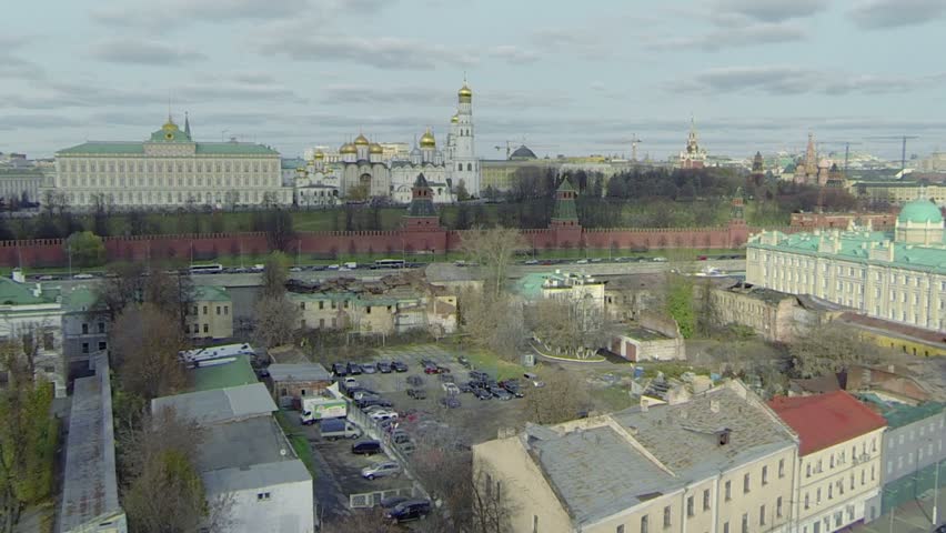 Car ride by road on quay near Kremlin wall at sunny day in Moscow 
