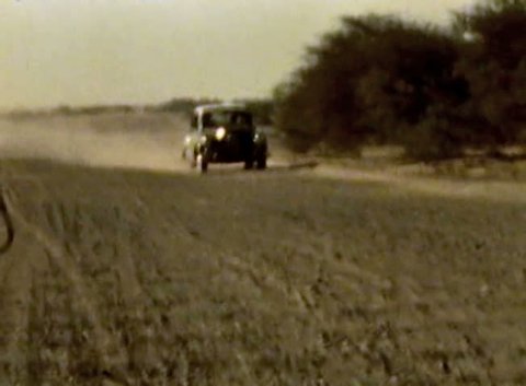ADEN PROTECTORATE - CIRCA 1960: car on desert dirt road in the British Aden Protectorate, southern Arabia. Vintage 8mm footage. Today territory is the Republic of Yemen.