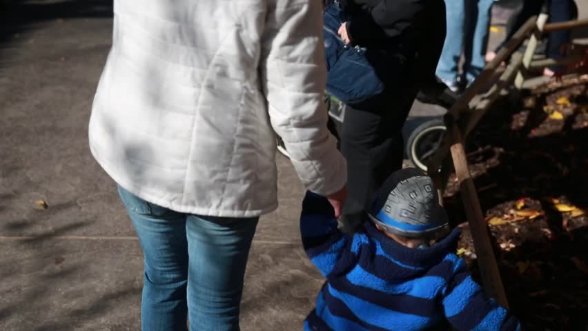 A mother with her baby boy walking around the zoo