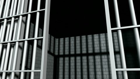 A static camera closeup of the door slamming shut a  brick jail cell with iron bars