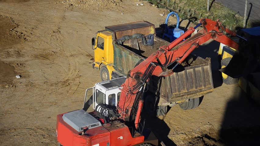 Construction Site - Stock Video. Front end loader loads truck with digging