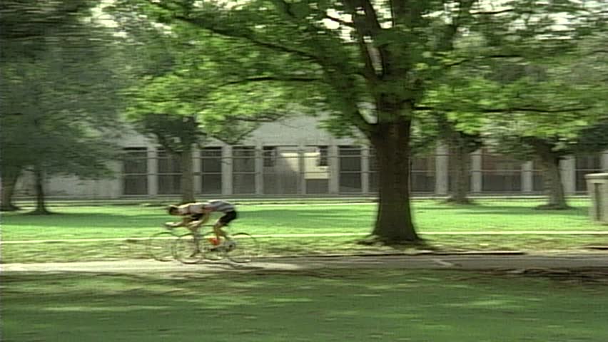Point of view from passenger train window of Bicycle riders in park