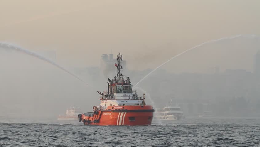ISTANBUL - OCT 29: Tugboat sprays arches of water backwards in celebration of