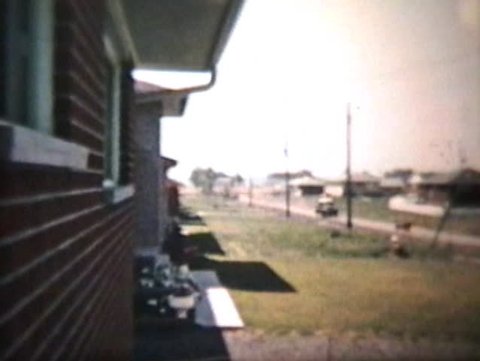 An Old Truck Passing By On A Suburban Road - Vintage 8mm film footage from 1960.